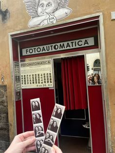 a person holding up some photos in front of a red door with the words fotoautomatica written on it