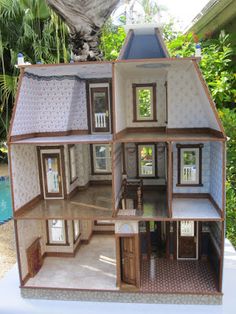 a doll house is shown with all the windows and doors open in front of a pool