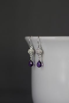 "Sweet faceted Purple Amethyst teardrops are carefully wire wrapped with silver wire onto Bali Silver rose flower links. These dangle from balled silver earwires. Wear these lightweight petite everyday to work or with your favorite jeans. Perfect for girls and women of any age. Bali Silver rose link: 7x12mm Amethyst teardrops: 5x7mm Total length of earrings: 1 1/4\" All silver is sterling. As the owner, maker, designer, and curator of this shop, I take great pride in providing you with jewelry t Purple Sterling Silver Teardrop Dangle Earrings, Purple Sterling Silver Teardrop Earrings For Gift, Purple Teardrop Crystal Earrings In Sterling Silver, Sterling Silver Teardrop Flower Earrings, Wire Wrapped Flower Earrings As Gift, Elegant Adjustable Wire Wrapped Teardrop Earrings, Elegant Wire Wrapped Briolette Teardrop Earrings, Sterling Silver Teardrop Pierced Flower Earrings, Elegant Nickel-free Briolette Earrings