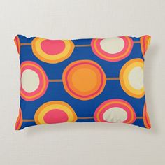 a blue pillow with orange, pink and yellow circles on it's back side