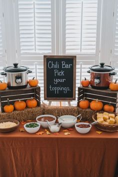 Warm and inviting chili bar setup for a November baby shower, featuring a chalkboard sign that reads 'Chili Bar, Pick your toppings,' surrounded by pumpkins and hay bales. Perfect for fall-inspired November baby shower ideas and November baby shower food options, with bowls of toppings like cheese, onions, and cornbread arranged on a rustic table. November Baby Shower Ideas, Fall Baby Shower Food, Fall Mantel Decorating Ideas, Fall Baby Shower Decor, Gender Reveal Food, Lil Pumpkin Baby Shower, November Baby Shower, Thanksgiving Baby Shower