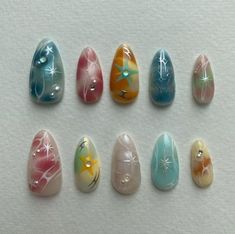 six different colored painted rocks on a white surface with starfishs and seashells