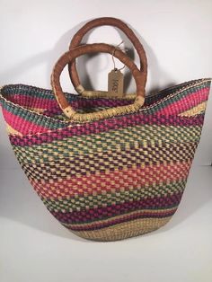 U-shopper basket is the perfect tote, beach bag, shopper, everyday bag, or home decor basket.  The beautiful bolga baskets are hand-woven in small villages of Ghana, a tradition passed down from generation to generation. They are woven out of renewable resource elephant grass, which grow abundantly in the region. Each basket is hand woven and 100% unique! The leather handle is treated using an all-natural process (either dyed and oiled or painted). Note that handle colors will vary and may range from black to an oiled red color.  Variations are to be expected and treasured. Baskets are sturdy, strong, and flexible. If properly cared for, your basket will live a long life. Details Large U-Shopper basket measures approx 16-18 inches across and 11-13" deep.   The basket is washable and collap Rectangular Beach Bag With Rolled Handles For Shopping, Eco-friendly Bucket Beach Bag With Rolled Handles, Eco-friendly Straw Bag With Rolled Handles For Shopping, Natural Basket Beach Bag With Rolled Handles, Casual Basket Beach Bag With Rolled Handles, Casual Beach Basket Bag With Rolled Handles, Woven Bucket Straw Bag For Shopping, Basket Beach Bag With Rolled Handles For Vacation, Brown Basket Beach Bag With Rolled Handles