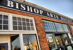 an old brick building with many windows and signs on the front door that say bishop arts district