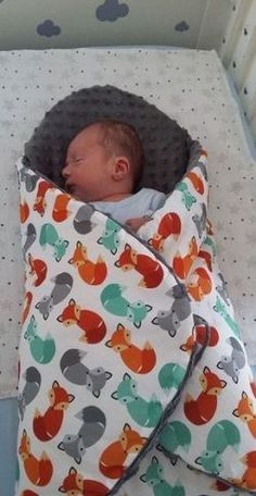 a baby sleeping in a crib next to a pillow