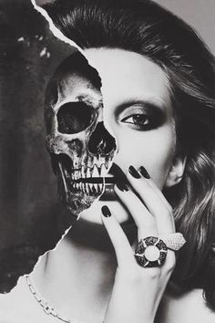 a woman holding her hand up to her face with a skull on it's cheek