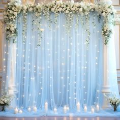 a wedding stage decorated with white flowers and lit candles for an elegant touch to the venue