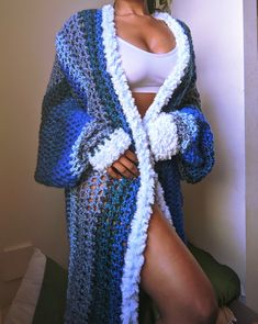 a woman wearing a blue and white crocheted cardigan