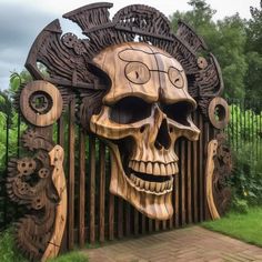 a large wooden sculpture with a skull on it's face in front of a fence