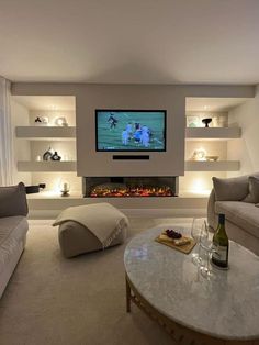 a living room filled with furniture and a flat screen tv mounted on the wall above a fireplace