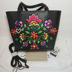 STUNNING HANDBAG WITH AMAZING VIBRANT COLORS AND EMBROIDERY WORK. DEFINITELY A STATEMENT PIECE. AGAINST A BLACK LEATHER BACKDROP, COLORFUL EMBROIDERY ECHOES THE FLORAL THE DESIGNER SAW ON HER VISIT TO INDIA. THE LOTUS, INDIA'S NATIONAL FLOWER, STANDS TALL IN THE MIDDLE BAG COMES WITH SLEEPER AND BRIGHTON BOX BRIGHTON JOURNEY TO INDIA RAYA FLORAL EMBROIDERED CROSSBODY SMALL TOTE $365 Width: 11" Height: 8" Depth: 4" Strap: 4 1/4" Additional Strap: 14" - 26" Adjustable Top Closure: Ziptop Interior Designer Embroidered Bags For Daily Use, Designer Embroidered Shopping Bag, Designer Embroidered Bags For Shopping, Designer Embroidered Shoulder Bag For Travel, Designer Embroidered Tote Bag, Floral Embroidered Tote Shoulder Bag For Shopping, Floral Embroidery Top Handle Shoulder Bag, Handmade Fabric Bags, National Flower