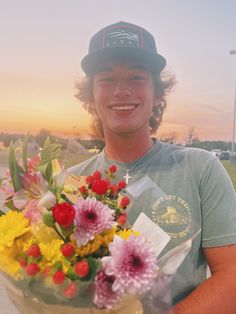 a young man holding a bouquet of flowers