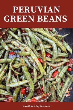 green beans with tomatoes and other vegetables in a frying pan on top of a table