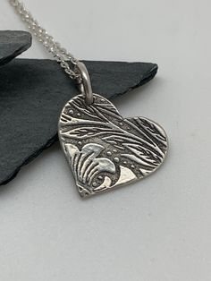 This beautiful silver floral leaf heart necklace pendant has been entirely handmade using .999 fine silver. It has been cut from fine silver precious metal clay, textured, fired and oxidized. The pendant hangs from a sterling silver diamond cut cable chain. This unique and handmade necklace features an embossed floral leaf branch pattern. Pendant size: approximately 5/8 x 5/8 inches Chain length: adjustable at 16 and 18 inches can also be customized to whatever length needed The necklace is sent Boho Jewelry Bracelet, Pendant Necklace Silver, Precious Metal Clay, Silver Heart Necklace, Bracelet Charm, Leaf Pendant, Metal Clay, Silver Pendants, Jewelry Bracelet