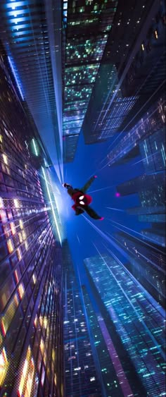 an airplane flying in the sky between two tall buildings at night with bright lights on them