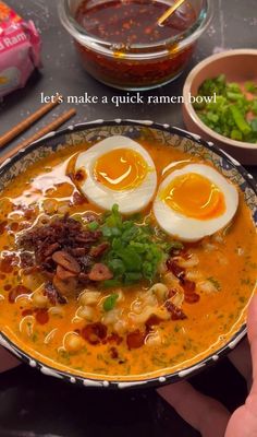 a person holding a bowl of soup with hard boiled eggs