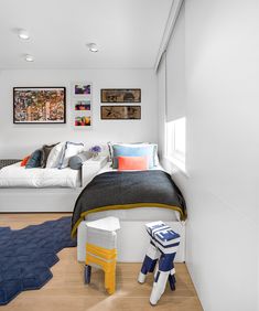 a bedroom with two beds and pictures on the wall above them, along with a blue rug