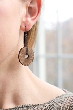 a close up of a woman's ear wearing earrings with circular designs on them