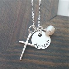 On this personalized silver cross necklace, there is a sterling silver cross charm, a hand-stamped 5/8" sterling silver disc, and a pearl, which all hang delicately from a fine 18" sterling silver chain. In the order notes section during checkout, please let us know the name you'd like us to stamp on the sterling silver disc. Each necklace is custom made to order! This elegant sterling silver cross necklace is unique not only because of the pearl charm but also because of what the cross charm me Necklace With Kids Names, Mom Necklace Personalized, Bible Verse Necklace, Personalized Cross Necklace, Silver Cross Necklace, Sterling Silver Cross Necklace, Viking Necklace, Mens Silver Necklace, Gold Name Necklace