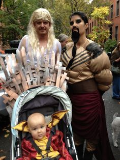 two people in costumes standing next to each other with a baby in a stroller