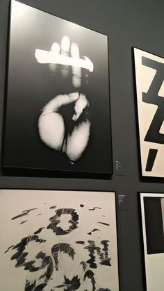 four black and white paintings hanging on the wall