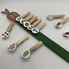 a group of wooden pegs sitting on top of a green piece of paper next to buttons