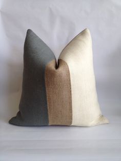 a pillow with two different colors on the front and one in grey, beige and white