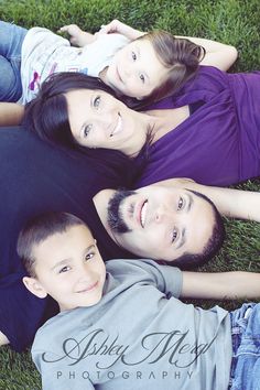 a family laying in the grass together