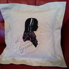 a white pillow with a silhouette of a woman's head and name on it