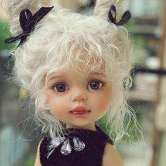 a close up of a doll with white hair and blue eyes wearing a black dress