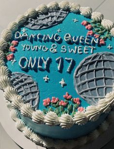 a cake that is sitting on top of a white plate with blue frosting and flowers