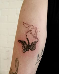 a woman's arm with a bird tattoo on it