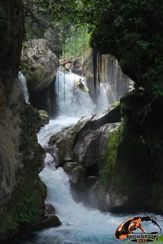 a man riding a surfboard on top of a waterfall