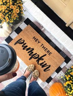 someone standing in front of a welcome mat that says hey there pumpkin