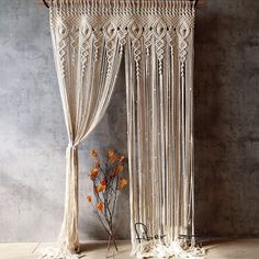 a macrame wall hanging with flowers in it