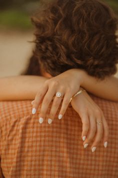 a close up of a person with their hands on her shoulder