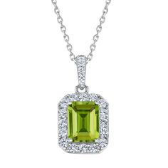 Vivid in color, this gemstone pendant necklace will add a luxuriant touch to any jewelry collection. Crafted in sterling silver, this pendant features an emerald-cut green peridot gemstone that is surrounded by round created white sapphire gemstones. Additional created white sapphires line bail of the pendant, for extra glisten and shine. The side of the pendant is decorated with a round peridot inside a heart detail and flourishing swirls, for a sweet surprise when viewed at an angle. This pend Formal Peridot Pendant Necklace, Emerald Cut Peridot Gemstone Jewelry, Green Pendant Gemstones For Formal Occasions, Elegant Lime Green Gemstone Necklace, White Gold Necklace With Gemstone Rectangular Pendant, Formal Peridot Gemstone Necklaces, Fine Jewelry Green Necklaces With Gemstone Accents, Elegant Lime Green Jewelry For May Birthstone, Green Emerald Cut Gemstone Necklace