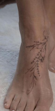 a woman's foot with a flower tattoo on it