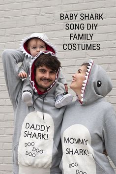 a man holding a baby in his arms while wearing a shark costume with the words daddy and me written on it