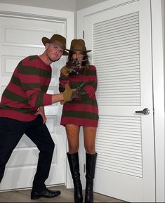 a man and woman dressed up in costumes standing next to each other near a door