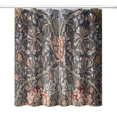 a curtain with an intricate floral design on the top and bottom, hanging from a metal rod