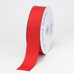 a roll of red satin ribbon on a white background