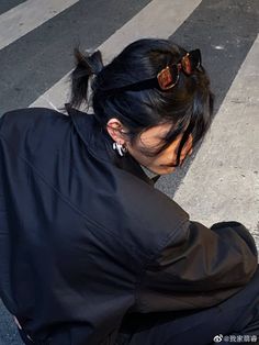 a woman sitting on the ground in front of a crosswalk with her head down