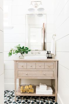 a bathroom with a sink, mirror and drawers