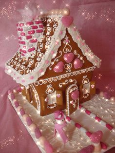 a gingerbread house decorated with pink and white icing