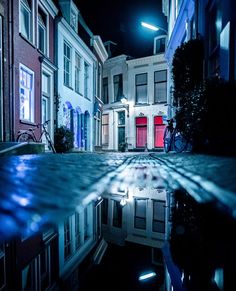 a reflection of buildings in the water at night