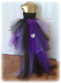 a purple and black dress on display in front of a door