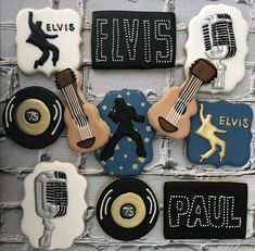 decorated cookies are arranged on a brick wall with the words elvis written in black and gold