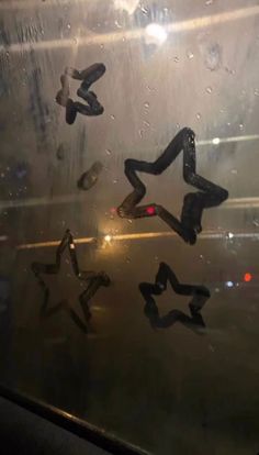 the reflection of two people in a window with raindrops