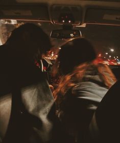 two people sitting in the back seat of a car